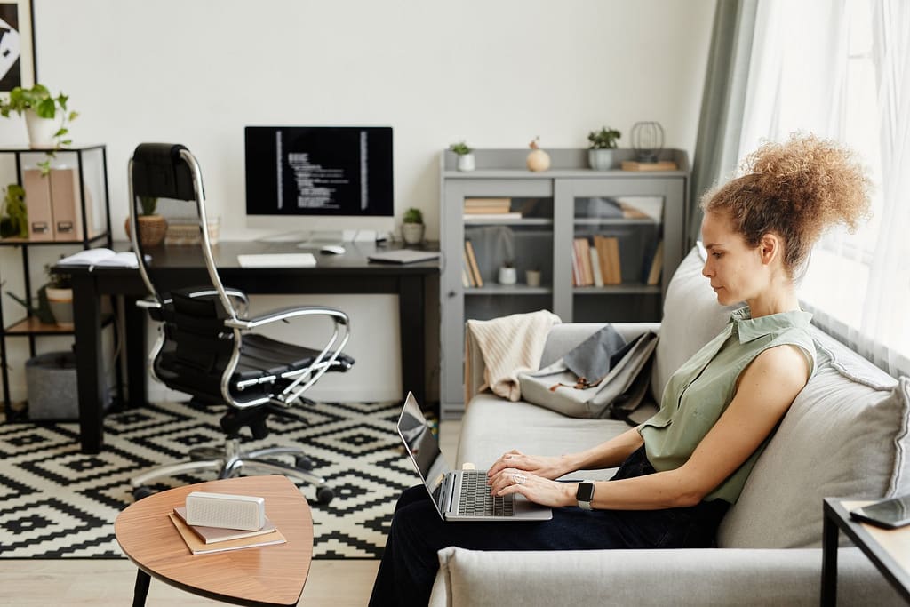 Woman sitting on sofa and working in the living room at home