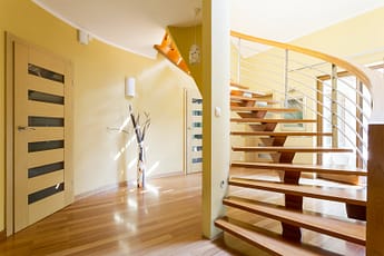 Spiral wooden staircase and doors in modern spacious interior